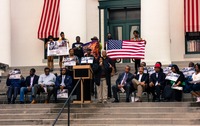 A woman gives a speech during the post-march rally for Trayvon Martin on the western steps of the Old Capitol (1845) on the forty-fourth anniversary of Dr. Martin Luther King, Jr.'s assassination.
