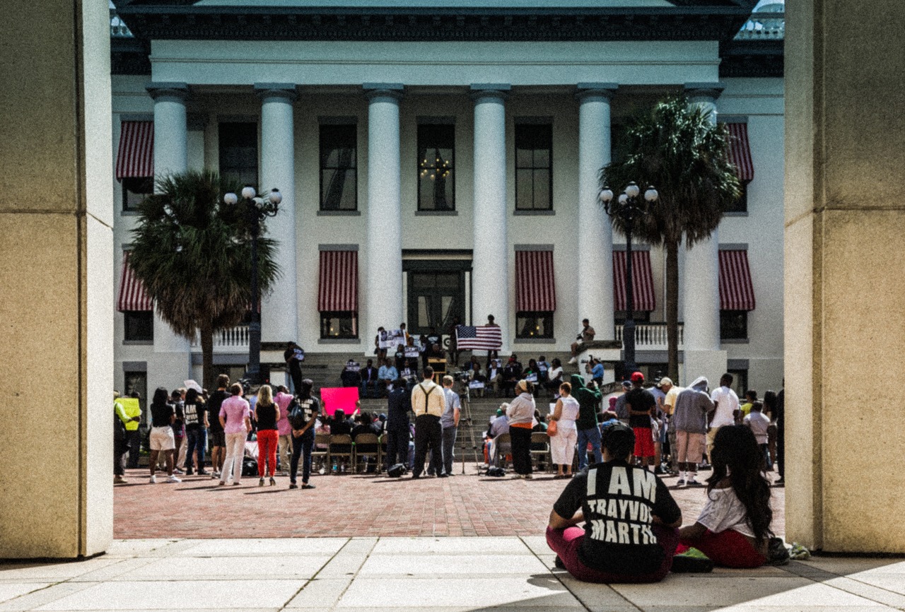 Spectators watch a man giving a speech during the post-march rally for Trayvon Martin on the western steps of the Old Capitol (1845) on the forty-fourth anniversary of Dr. Martin Luther King, Jr.'s assassination.