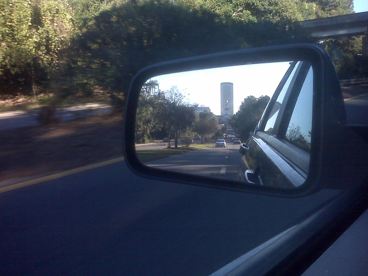 The historic (1845) and modern (1977) Florida State Capitol buildings reflected in my mirror.