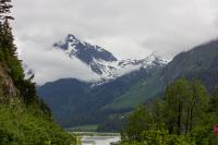 Snow and trees on a cloudy mountainside in the valley along the braided Resurrection River from a turnout not far from Exit Glacier.