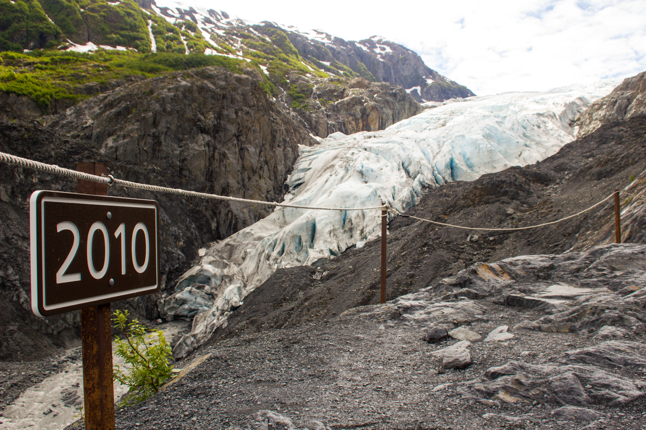 A sign at a lookout at the end of the Edge of the Glacier Trail showing that Exit Glacier was at this point in 2010, now receded into the distance beyond.