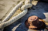 A rusty bolt and twists of rope on the wooden frame of an umiak, an Iñupiat seal skin whaling boat, along the shore of the icy Chukchi Sea, Arctic Ocean.