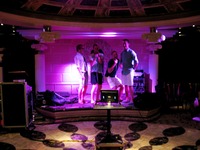 Four passengers enjoying karaoke at the LGBT meet at Michelangelo Lounge, Deck 9 on Carnival Sensation.