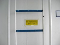 'Do Not Climb This Ladder' sign at the white and blue ladder to the hatch for lifeboats 4, 6 and 8, seen on the Deck 10 port exterior corridor on Carnival Sensation.