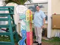 Jeff Porter standing next to the 'you must be this tall to drink' sign outside Señor Frog's Bar & Restaurant.