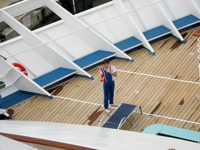 One of the ship's crew who came to Deck 7 forward to make last minute telephone calls before heading to sea, seen from the Deck 11 forward lookout above the bridge on Carnival Sensation.