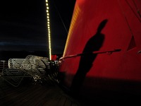 Chris Benitez casts a shadow on the ship's smokestack from the Deck 12 starboard deck on Carnival Sensation.