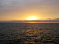 The sun sets over the Atlantic Ocean, seen from the Deck 10 starboard exterior corridor on Carnival Sensation.