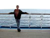 Chris Benitez and the Atlantic Ocean along the Deck 10 starboard exterior corridor on Carnival Sensation.