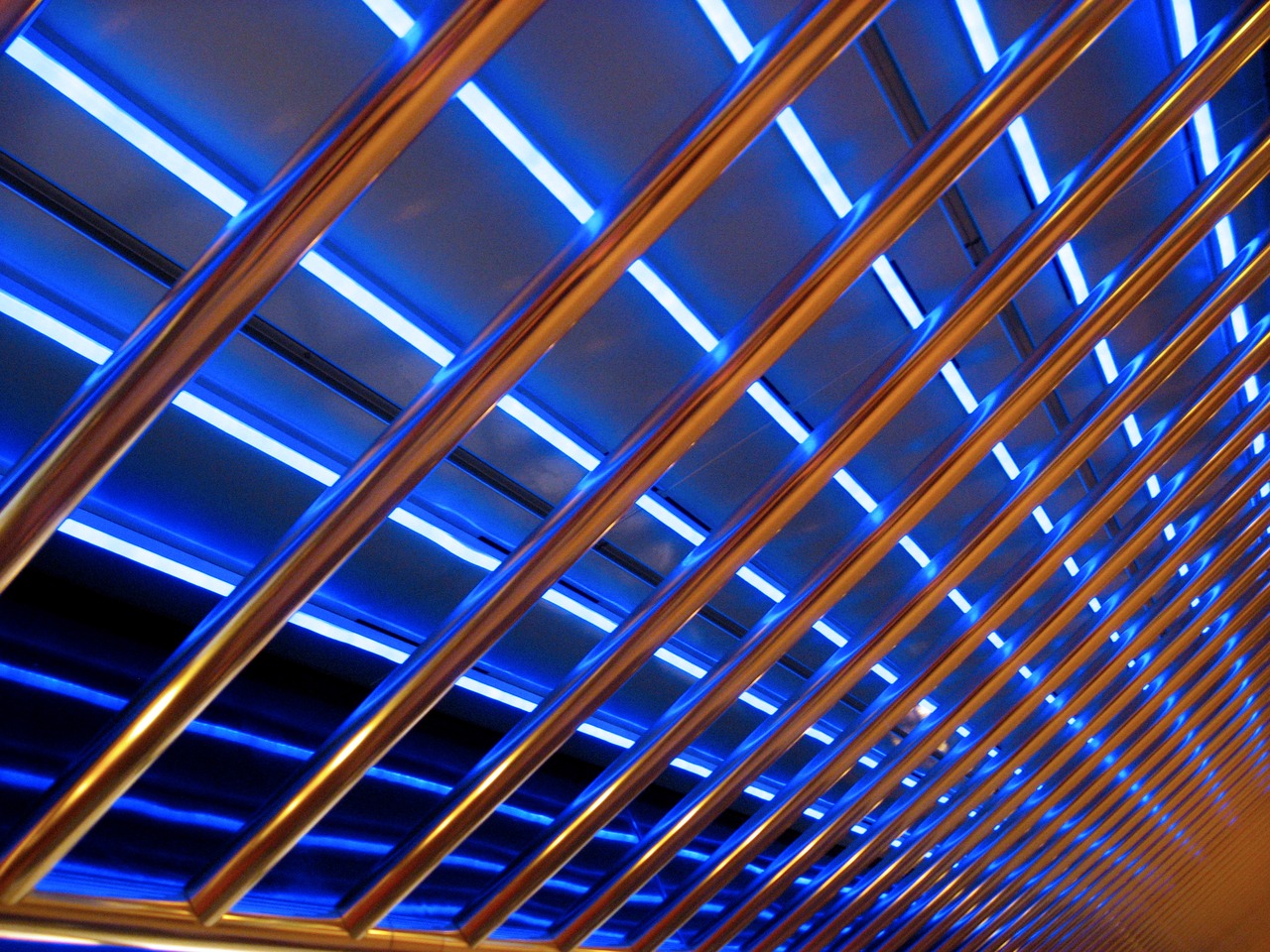 Blue neon lights behind metal bars above the Deck 10 starboard interior corridor near the Seaview Bar & Grill on Carnival Sensation.