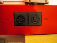 Faces of the 220 volt and 110 volt electrical outlets, seen in Cabin E-220, Deck 7 port aft on Carnival Sensation.