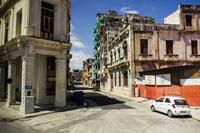 A residential block with balconies, automobiles and pedestrians on Consulado off Paseo del Prado in Havana, Cuba.