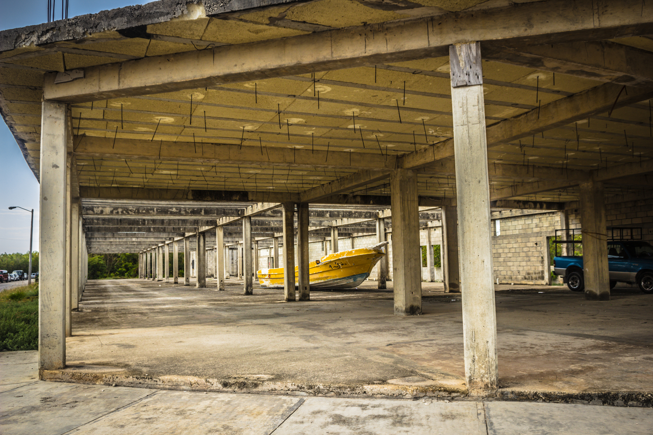 A yellow boat abandoned in the middle of an unfinished building two blocks away from Puerto Costa Maya in Costa Maya, Mexico.