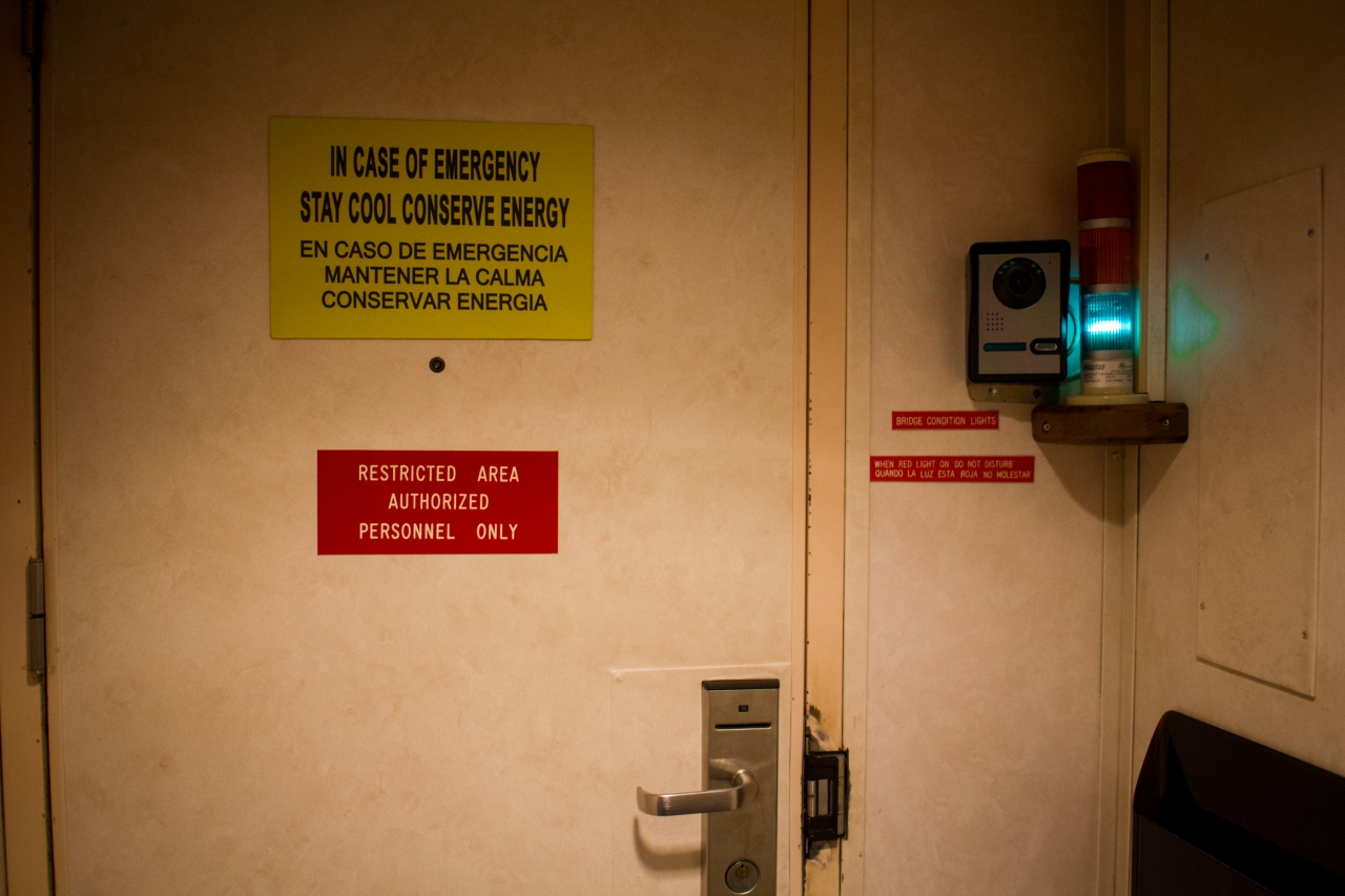 Signs, security camera and alert condition lights on the door leading to the Bridge on Deck 9 during an All Access Tour of the MS Empress of the Seas.