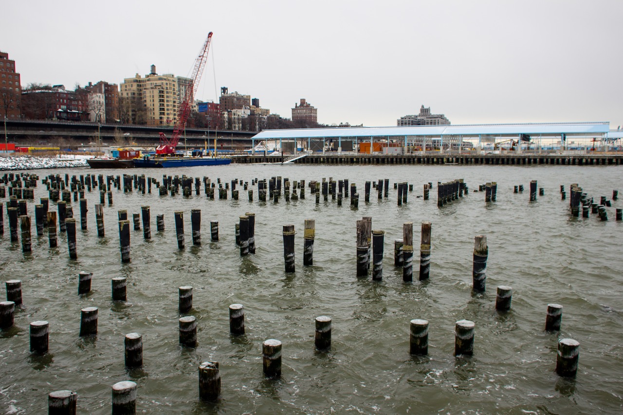 Centenarian wood pylons in the East River, Pier 2 and Brooklyn Heights residences along the Brooklyn-Queens Expressway (1954) from the southwest corner of Brooklyn Bridge Park (2010) Pier 1.