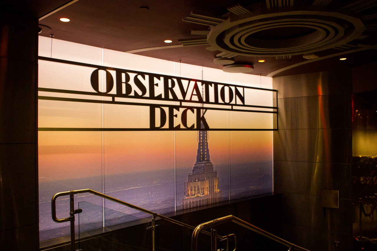 A sign and backlit photograph welcomes visitors to the 86F observation deck of the Empire State Building (1931).