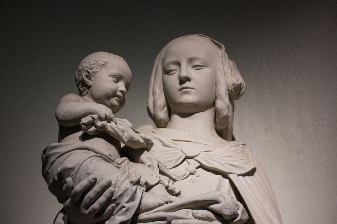 Statue of a woman holding an infant on display in the Great Hall of the College of Fine Arts Building (1916) at Carnegie Mellon University.
