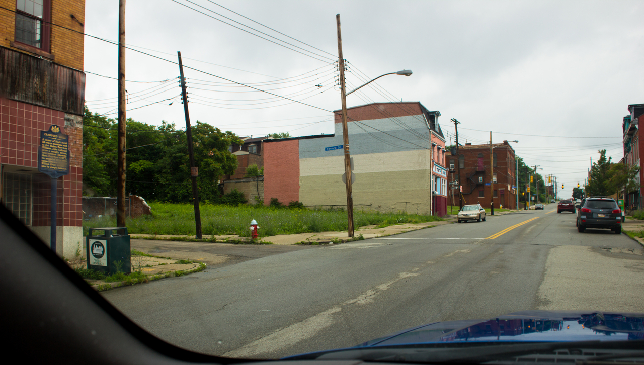 The Sochatoff Building (1917) and Crawford Grill historical marker, Tim's Bar and the vacant lot of 2161 Wylie Avenue in the Hill District of Pittsburgh.