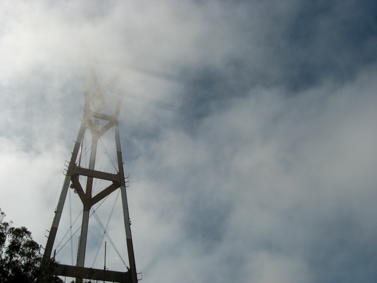 Sutro Tower casting shadows in the fog as seen from the neighborhood below.