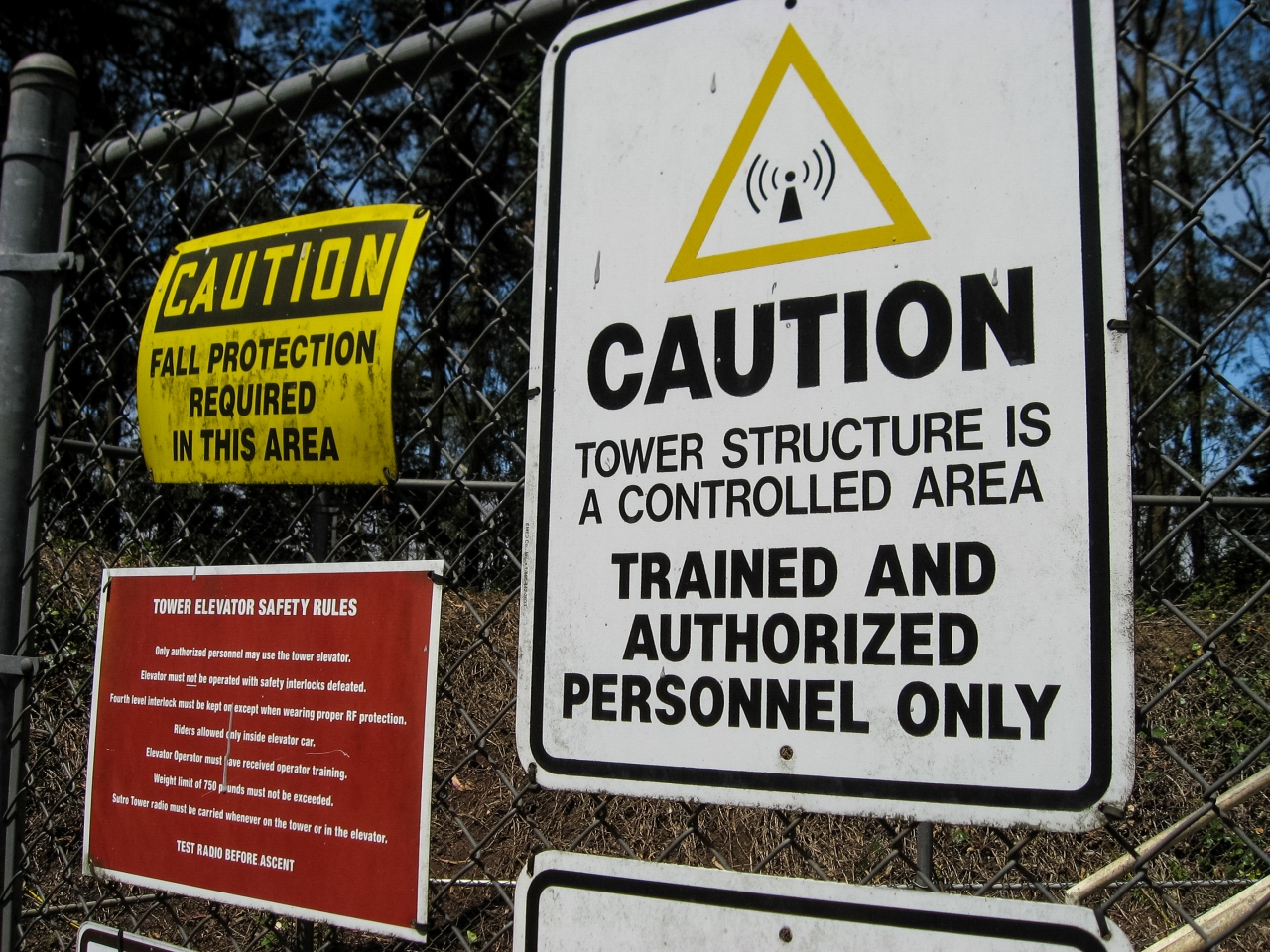 Fall Protection, Authorized Personnel Only and Tower Elevator Safety Rules signs just outside the Sutro Tower western leg and elevator.