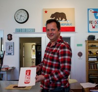 Eric Rewitzer posing with my hand pulled linocut print from his painted linoleum sheet carved with Sutro Tower artwork.