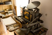 Printing press with logotypes ready for printing in the back workroom of 3 Fish Studios.