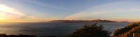Sunset panorama of the Golden Gate strait: the Pacific Ocean, Marin Headlands, Mile Rock Lighthouse (1906) and Golden Gate Bridge (1937) from the Lifesaving Station Overlook on the Coastal Trail at Lands End in the Golden Gate National Recreation Area.