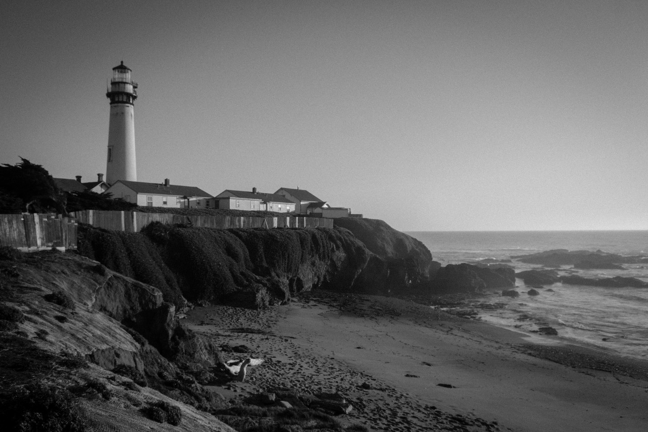 Pigeon Point Lighthouse (1871), buildings, beach and the rocky shore of the Pacific Ocean.