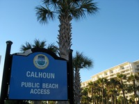 Sign for 'Calhoun Public Beach Access' next to Signature Beach Condominium.