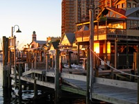 The setting sun reflects off The Lucky Snapper Grill & Bar from the HarborWalk Marina.