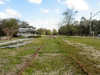 High Springs Chamber of Commerce building (2008) and the old Savannah, Florida and Western Railroad tracks (1884) running southeast through High Springs near Main Street.