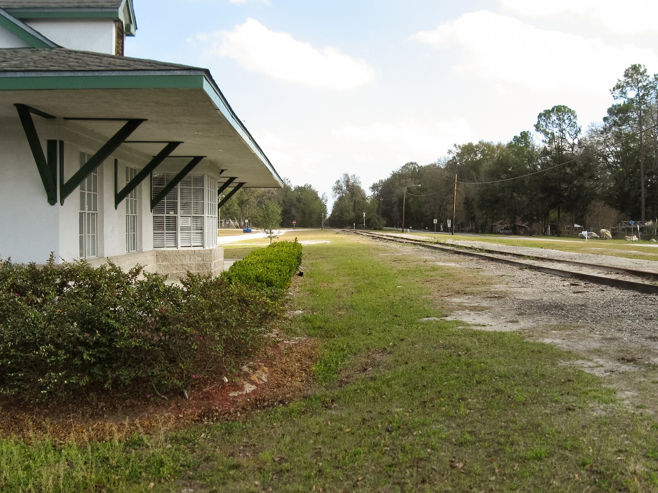 High Springs Chamber of Commerce building (2008) and the old Savannah, Florida and Western Railroad tracks (1884) running southeast through High Springs near Main Street.