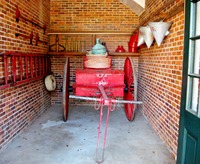 Antique bicarbonate soda chemical fire engine and other firefighting apparatuses in the Firehouse (1929) at Pebble Hill Plantation.