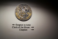 Seal of the Florida House of Representatives along with directional signage for the sergeant at arms, clerk and chaplain on the fifth floor of the Florida Capitol (1977).