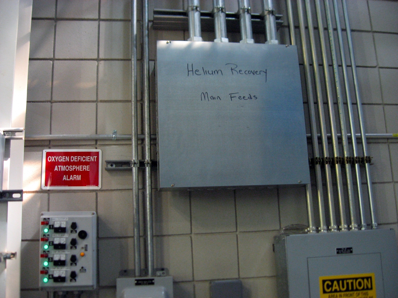 Helium recovery main feeds and oxygen deficient atmosphere alarm controls in the DC Field wing test cell corridor.