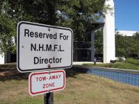 Parking lot sign: Reserved for N.H.M.F.L. Director.