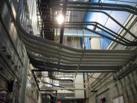 Pipes and cables overhead the DC Field wing test cell corridor.