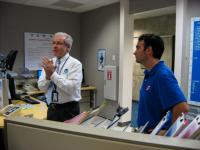 Public Affairs Officer Dennis Feltgen and Hurricane Specialist John Cangialosi discussing the functions and roles performed in the operations center of the National Hurricane Center.