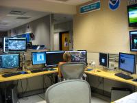 A NOAA staffer operates a console at the Atlantic/Pacific Analysis Desk in the Tropical Analysis and Forecast Branch unit of the National Hurricane Center.