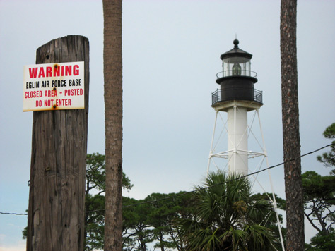 Photo Credit: David July — "Warning Eglin Air Force Base Closed Area - Posted Do Not Enter" sign and the Cape San Blas Lighthouse (1885) from Cape San Blas beach, Eglin Air Force Base, Test Site D3A, Cape San Blas Light Drive at Keepers Cottage Way, Port St. Joe, Florida, 21 August 2010