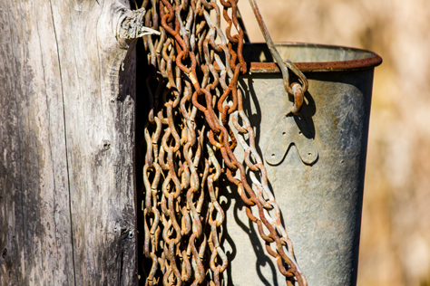 Photo Credit: David July — Metal bucket and chains hanging on the well's wooden arch at Dudley Farm Historic State Park, Newberry, Florida: 16 February 2014