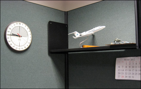 Photo Credit: David July — Twenty-four hour clock and NOAA aircraft model in the office of CARCAH, the Chief Aerial Reconnaissance Coordination All Hurricanes unit of the National Hurricane Center, 11691 SW 17th Street, Miami, Florida, 15 May 2012
