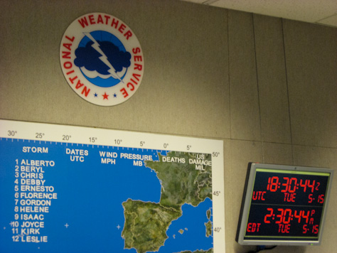 Photo Credit: David July — NWS logo, tracking map and a clock in the operations center of the National Hurricane Center, 11691 SW 17th Street, Miami, Florida, 15 May 2012