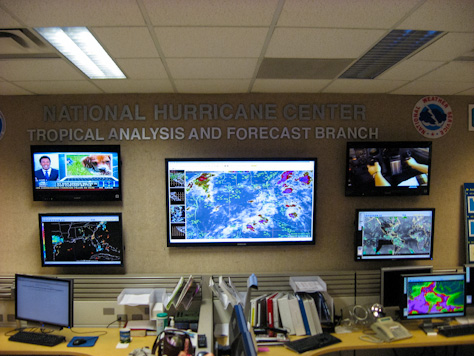 Photo Credit: David July — Sign, NWS logo and wall-mounted displays in the Tropical Analysis and Forecast Branch unit of the National Hurricane Center, 11691 SW 17th Street, Miami, Florida, 15 May 2012