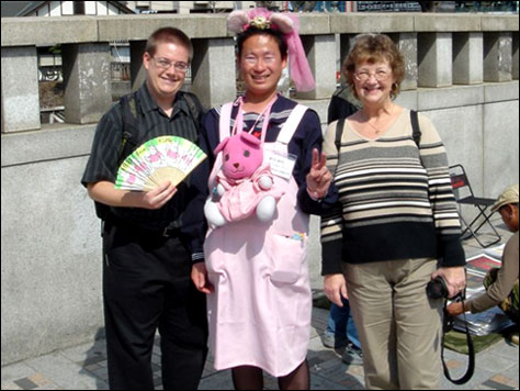 Photo Credit: Steven Patten — David and Mom pose with the guy in pink near the Meiji Shrine, Harajuku, Tokyo, Japan, 16 March 2008