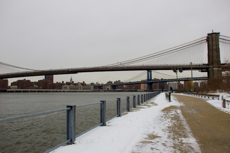 Photo Credit: David July — The Brooklyn Bridge (1883), Manhattan Bridge (1909) and Empire State Building (1931) beyond from the riverside path at Brooklyn Bridge Park (2010) Pier 1, Brooklyn, New York: 26 January 2014