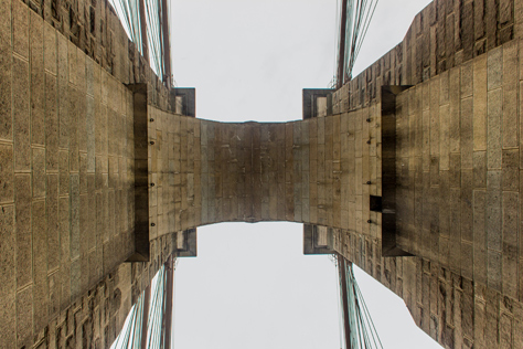 Photo Credit: David July — Looking up under the eastern tower of the Brooklyn Bridge (1883) from the pedestrian and cyclist promenade, Brooklyn, New York: 26 January 2014
