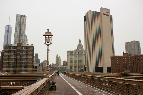 Photo Credit: David July — Walking toward the Manhattan approach of the Brooklyn Bridge (1883) on the pedestrian and cyclist promenade, Manhattan, New York: 26 January 2014