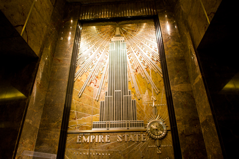Photo Credit: David July — Restored wall mural and signage behind the reception desk in the lobby of the Empire State Building (1931), New York, New York: 23 January 2014