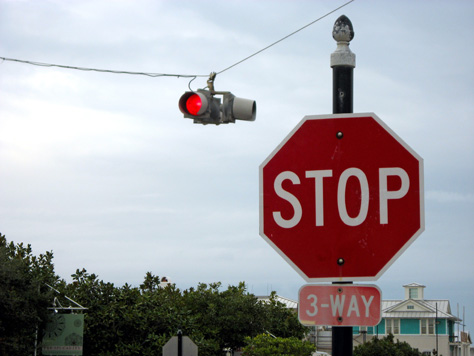 Photo Credit: David July — The sole traffic signal on Highway 30A in Seaside and a 3-way stop sign, Central Square at East County Highway 30A, Seaside, Florida, 26 November 2010
